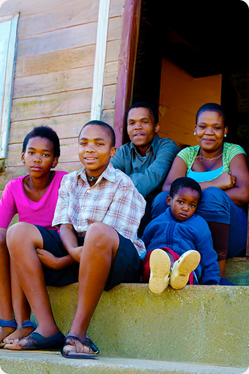 Haitian family sitting on the front step of an apartment